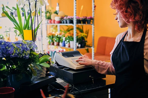 Female flower seller using cash register