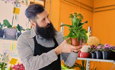 Sakallı erkek satıcı çiçek tutan