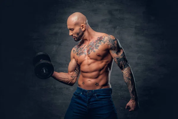 Shirtless man in a jeans holds the dumbbell — Stock Photo, Image