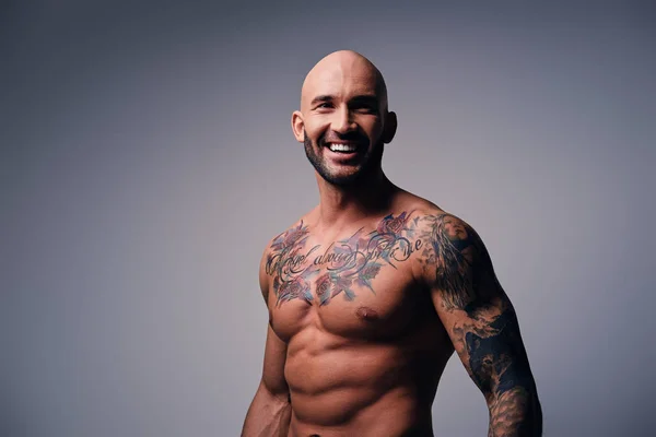 Посміхаючись без сорочки чоловік з татуюваннями — стокове фото