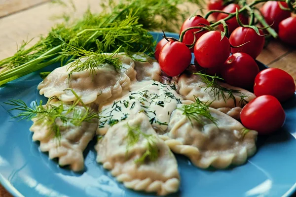 Heerlijke dumplings met peterselie op een blauw bord — Stockfoto