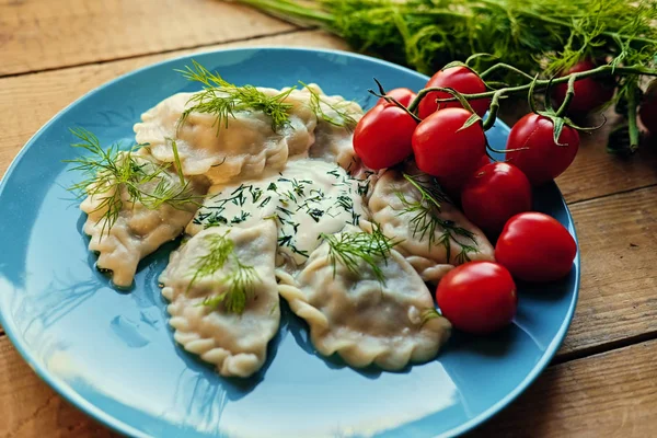 Heerlijke dumplings met peterselie op een blauw bord — Stockfoto