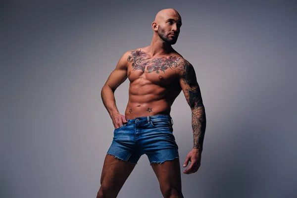Muskularny mężczyzna z tatuażami na jego tors — Zdjęcie stockowe