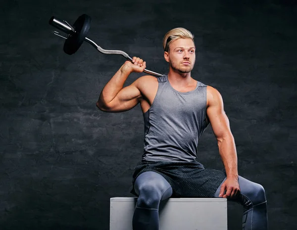 Atletik erkek halter tutar