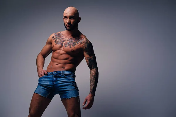 Muskulös man med tatueringar på hans överkropp — Stockfoto