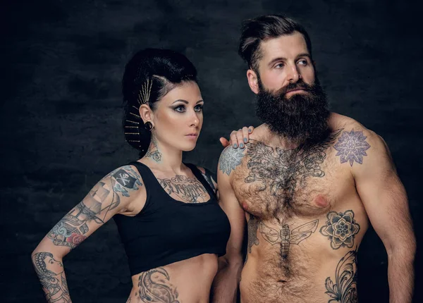 Studio portrait of tattooed couple