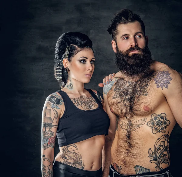 Studio portrait of tattooed couple
