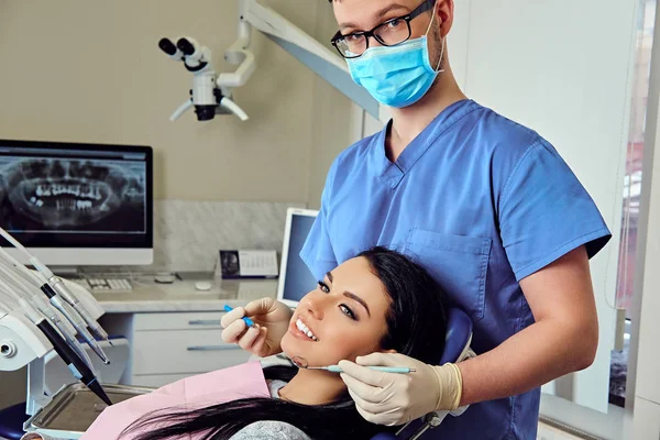 Dentista examinando os dentes femininos — Fotografia de Stock