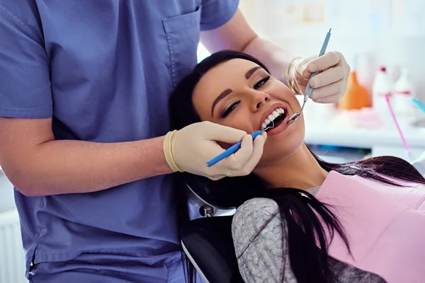 Zahnarzt untersucht weibliche Zähne — Stockfoto