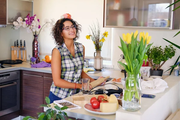 Kvinna i ett kök med en massa blommor — Stockfoto