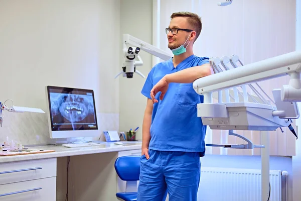 Bonito dentista masculino em um quarto — Fotografia de Stock