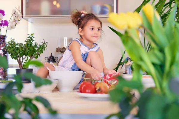 Linda niña se sienta en una cocina —  Fotos de Stock