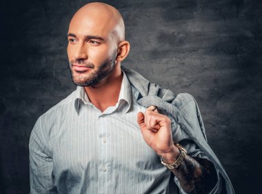 Dövmeli kollu adam ceket tutar
