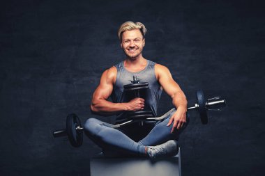 Sarışın adam gülümseyen halter tutar