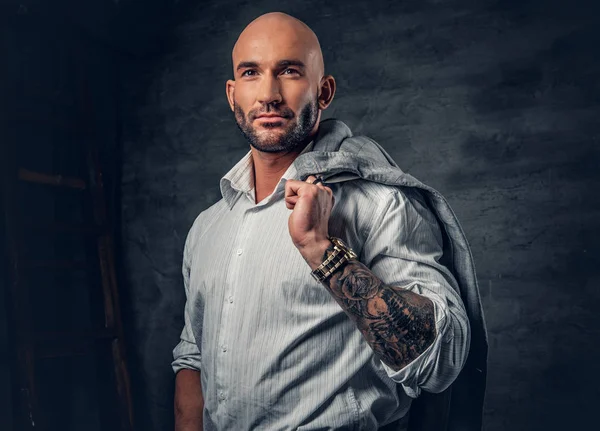 Homem com braço tatuado segura jaqueta — Fotografia de Stock