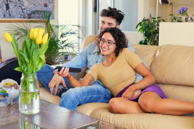 Çift kanepede oturan ve tv kanalları arasında geçiş yapma