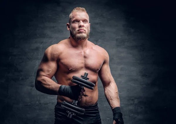 Muscular man holds dumbbell — Stock Photo, Image