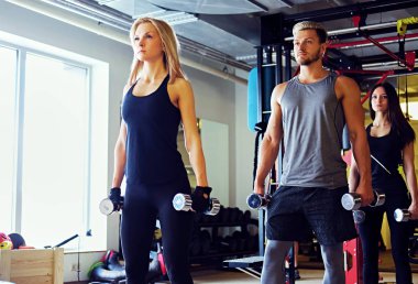 Adam ve kadın dumbbells ile egzersiz yapıyor