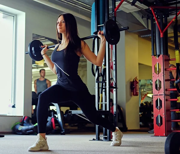 Femme sportive faisant squats avec haltère — Photo