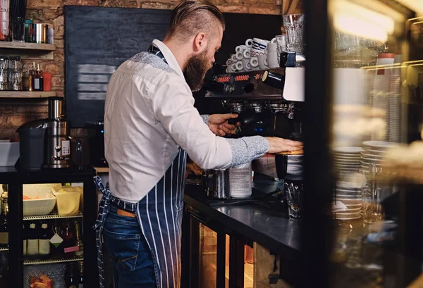 En skjeggete mann lager kaffe – stockfoto