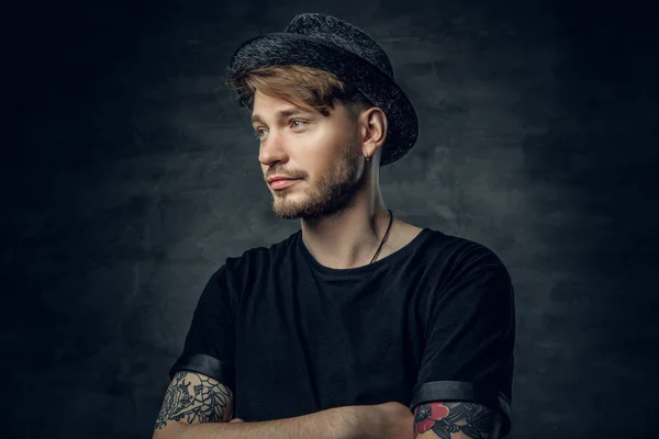 Man in a black t shirt and tweed hat — Stock Photo, Image