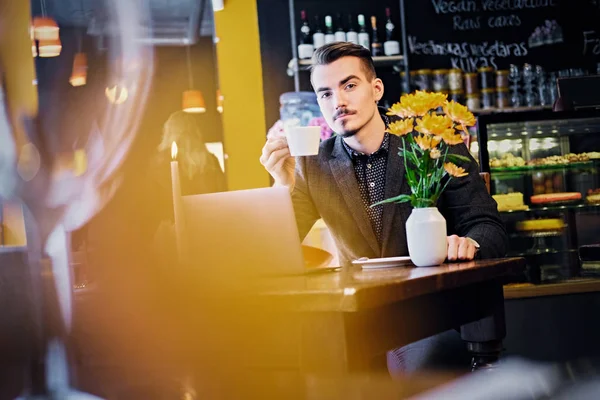 Ο άνθρωπος πίνει καφέ και χρησιμοποιούν φορητό υπολογιστή — Φωτογραφία Αρχείου