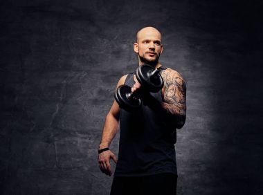 Adam bir dumbbell tutar.