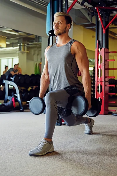 Atletische man doen squats met halters — Stockfoto