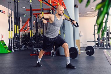 Trx egzersizleri yapıyor atletik erkek