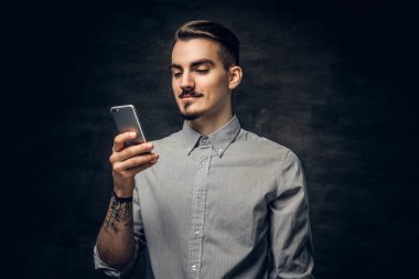 Bir akıllı telefon kullanan sakallı adam