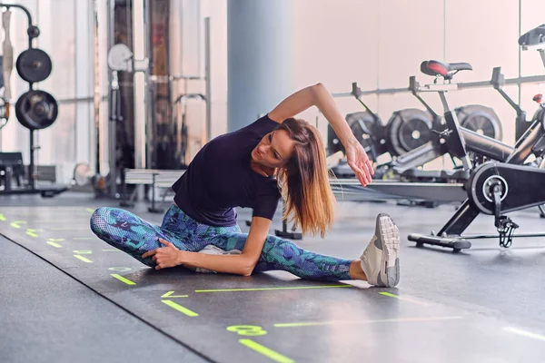 Fille sportive étirant sur un sol — Photo