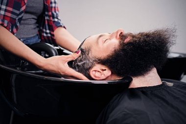 Hairdresser washing man's hair clipart