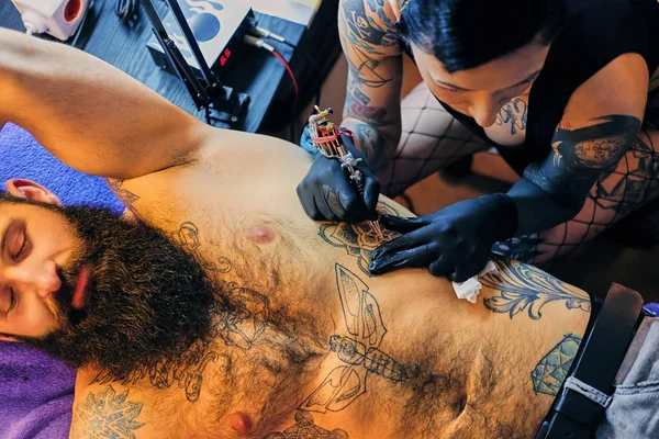 Tattoo kunstenaar maakt tatoeage op mannelijke torso — Stockfoto
