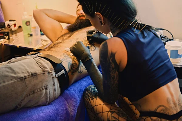 Художник татуювання робить татуювання на чоловічому торсі — стокове фото