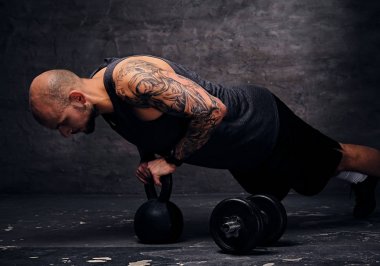Gönderme yapan erkek ups Kettlebell üzerinde.