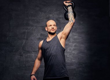 Kettlebell ile omuz egzersiz yapan erkek.