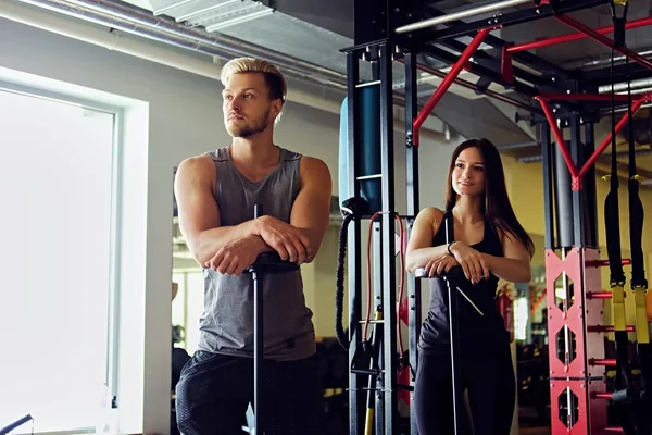 Atletisk man och kvinna i ett gym. — Stockfoto