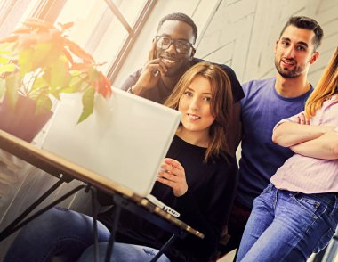 Bir dizüstü bilgisayar kullanan çok ırklı öğrenciler