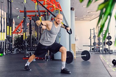 Trx egzersizleri yapıyor atletik erkek