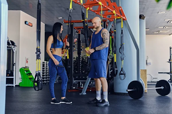 Homme et femme brune mince dans la salle de gym — Photo