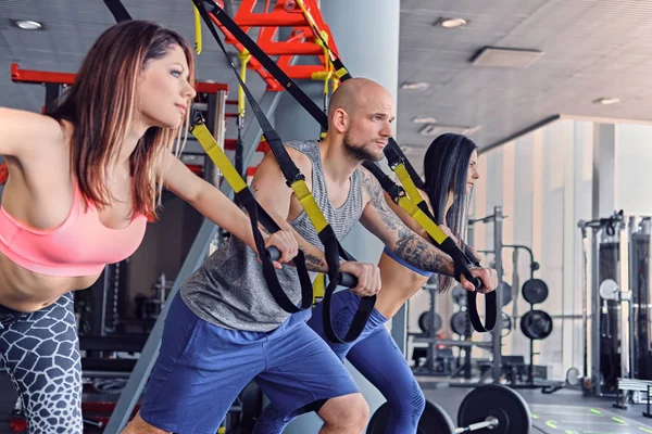 Man and women doing trx exercises — Stock Photo, Image