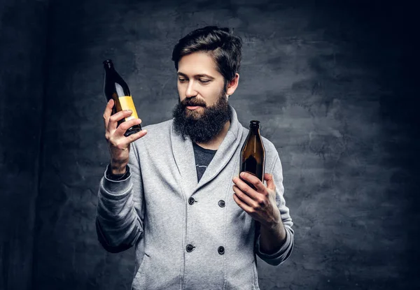 ひげを生やした男性が瓶ビールを保持します。 — ストック写真