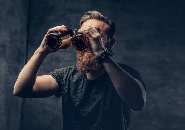 Uomo divertente guardando attraverso bottiglie di birra — Foto Stock