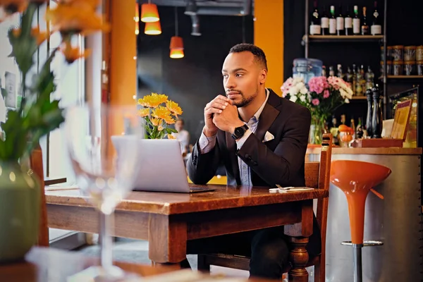 Homme noir utilisant un ordinateur portable dans un restaurant — Photo