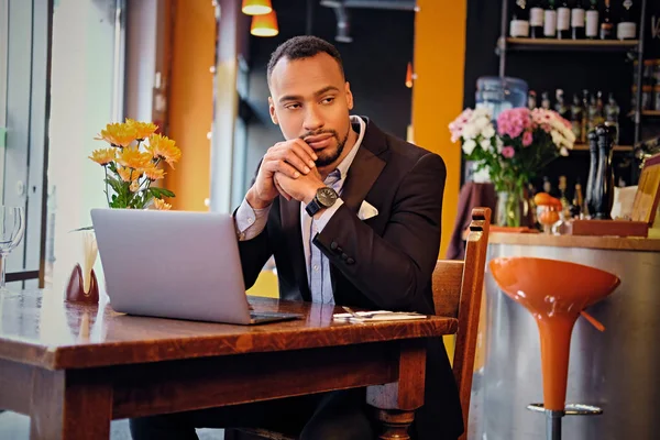 El hombre reflexivo en un café con el ordenador portátil —  Fotos de Stock