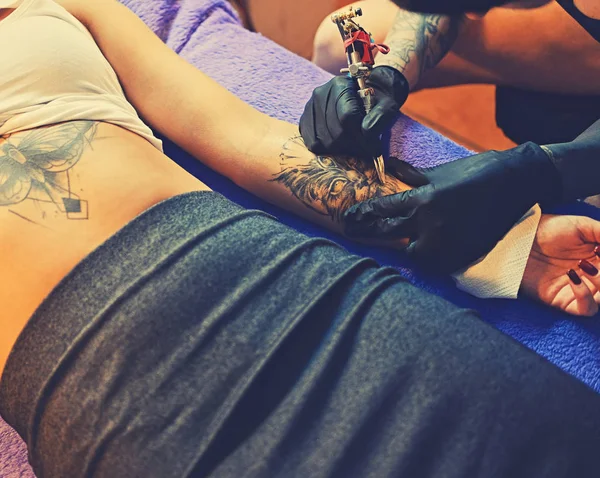 Hacer un tatuaje en el brazo de una mujer . — Foto de Stock