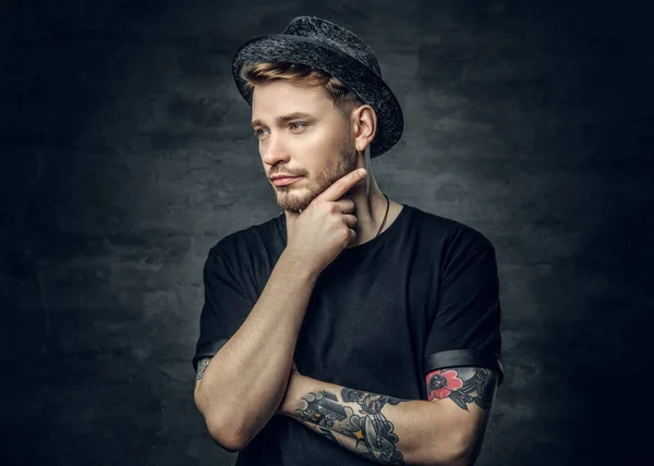 Thoughtful male with crossed tattooed arms — Stock Photo, Image