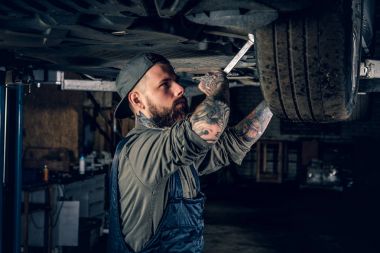 Bir atölyede dövmeli makinist.