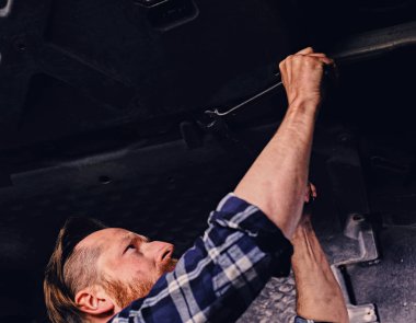 Mekanik bir atölyede çalışan sakallı