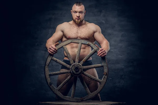 Man poseren met oude houten wiel — Stockfoto